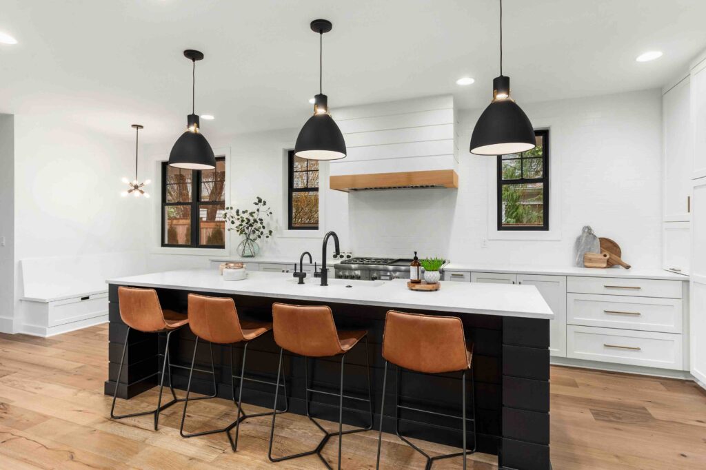 Beautiful white kitchen with dark accents in new modern farmhouse style luxury home