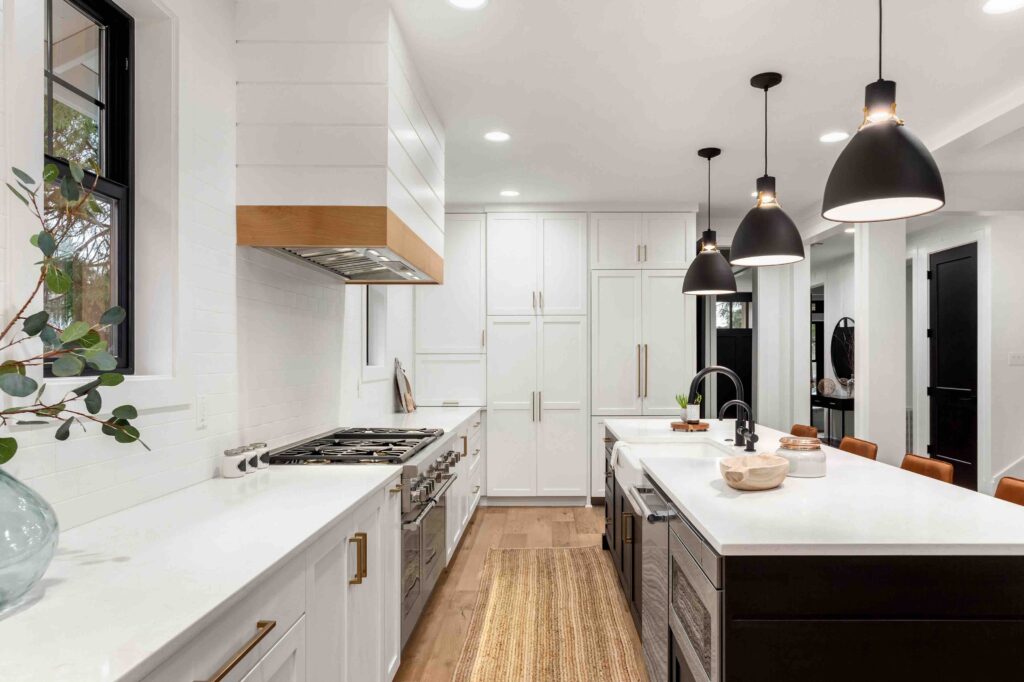 Beautiful white kitchen with dark accents in new modern farmhouse style luxury home