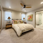 Modern bedroom remodel in Los Angeles with wood flooring, ceiling fan, and neutral finishes by Buildwright Construction
