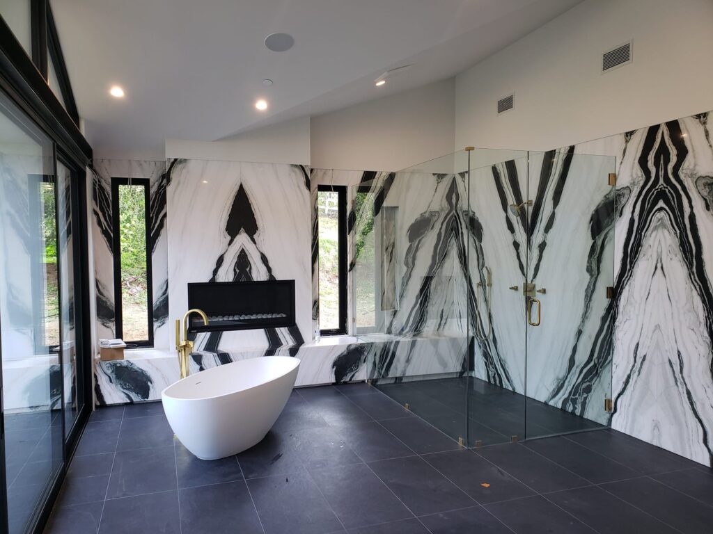luxury bathroom remodel Los Angeles bookmatched marble walls freestanding tub glass shower